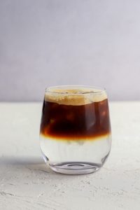 Café Tónic de Bonafide servido en un vaso con hielo, agua tónica burbujeante y un shot de café molido, perfecto para disfrutar en días calurosos.